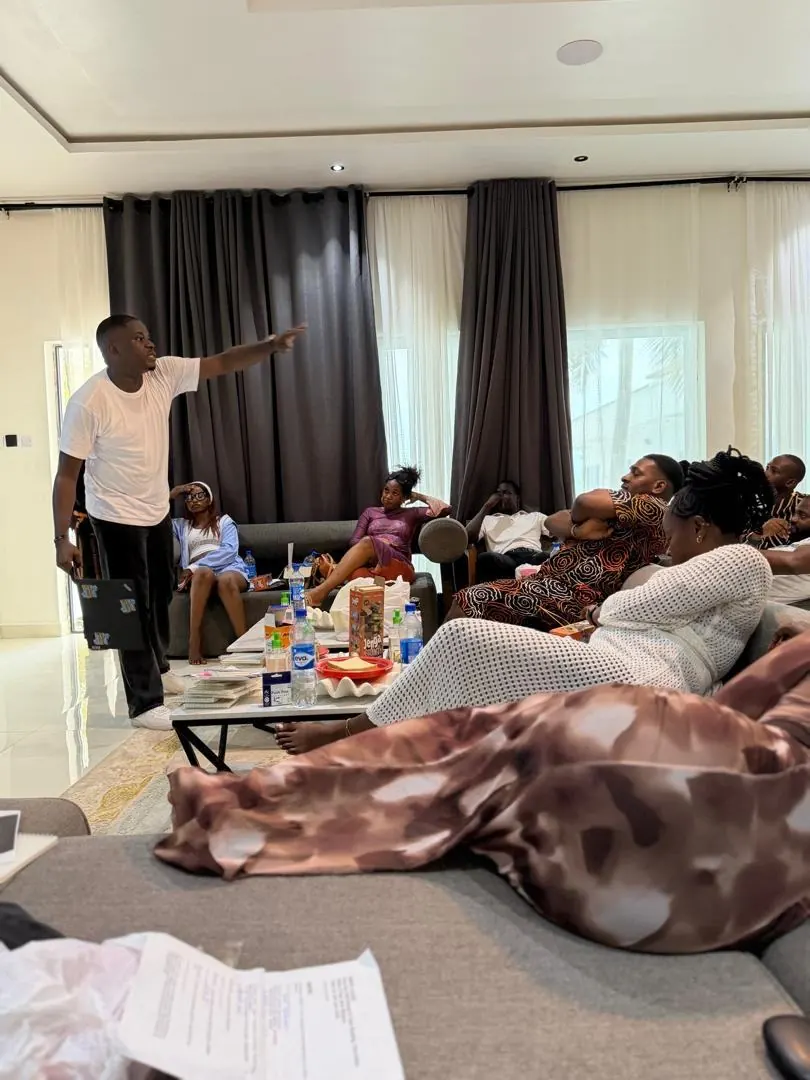Ayodeji leading a training session with company staff seated on sofas